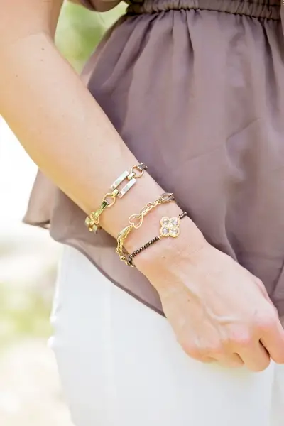 closeup of woman wearing two-toned yellow gold and silver chain bracelets