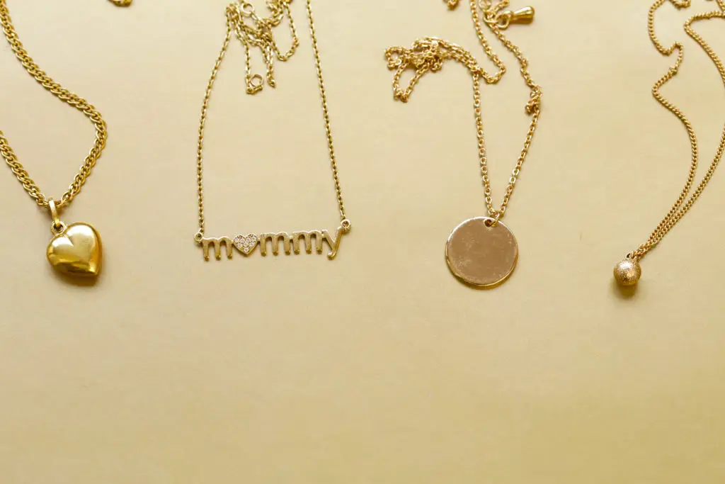 gold pendant necklaces on a tan background