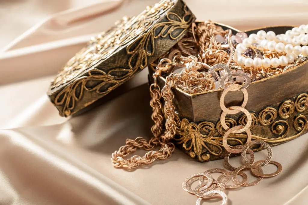 heart-shaped jewelry box overflowing with gold jewelry