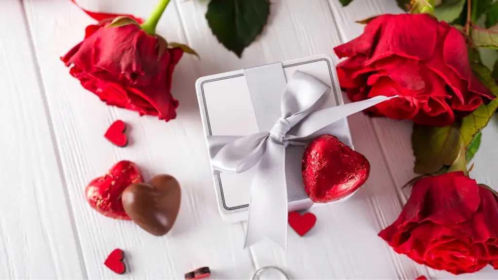 Valentine's Day themed white jewelry box with chocolate and roses on a white wooden background