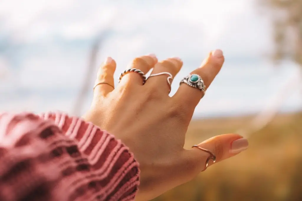 woman's hand with different rings on each finger