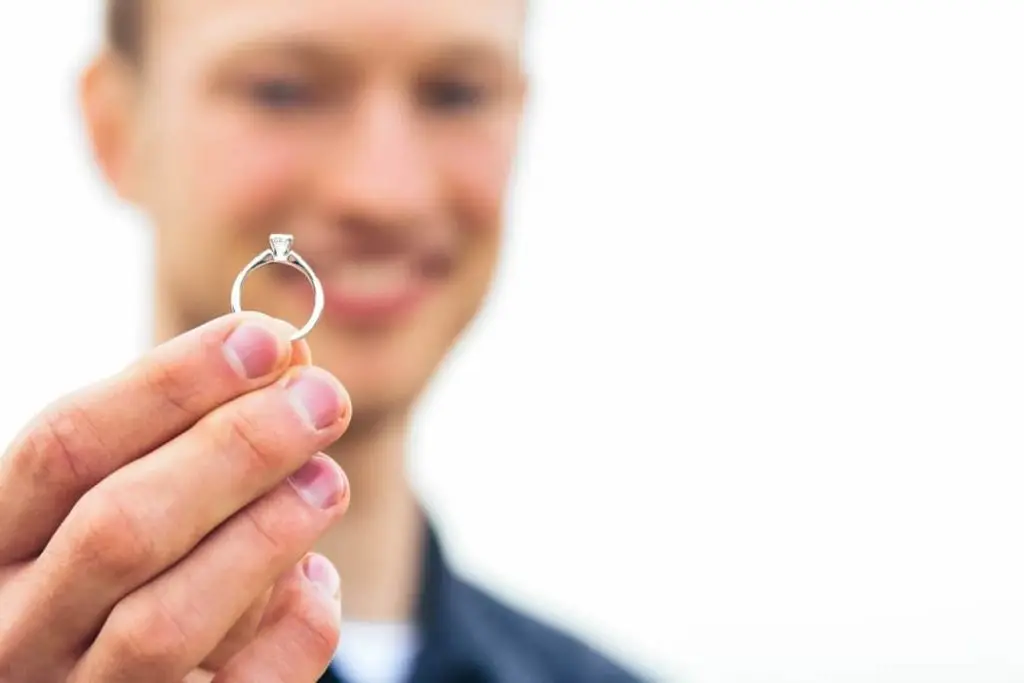 man holding a diamond engagement ring