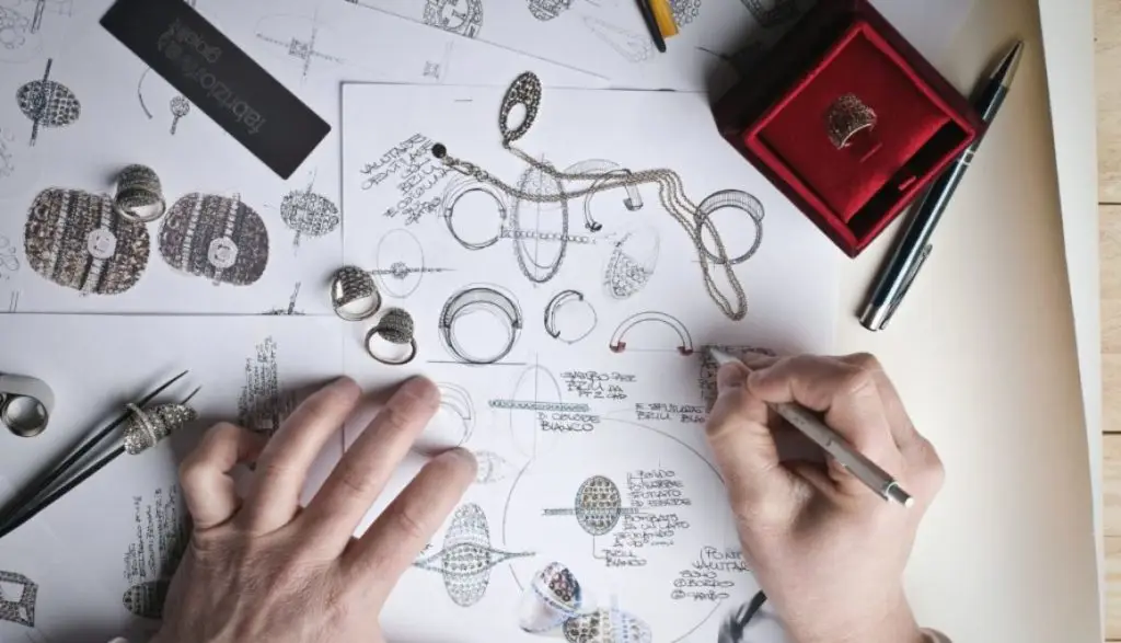 person drawing designs for custom jewelry