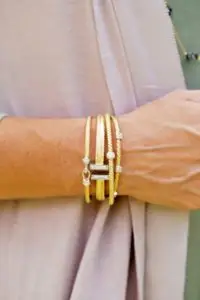 closeup of woman wearing a stack of mixed metal charles garnier bangle bracelets