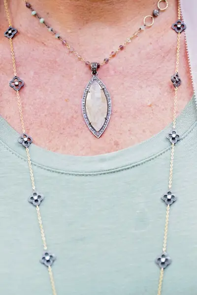 closeup of marquise quartz and diamond necklace around a woman's neck