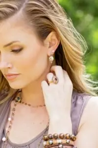 woman wearing medallion earrings and garnet ring