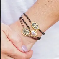 closeup of stackable quartz medallion stretchy bracelets on woman's arm