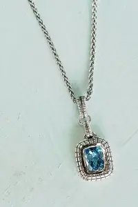 sterling silver blue topaz necklace with a white background