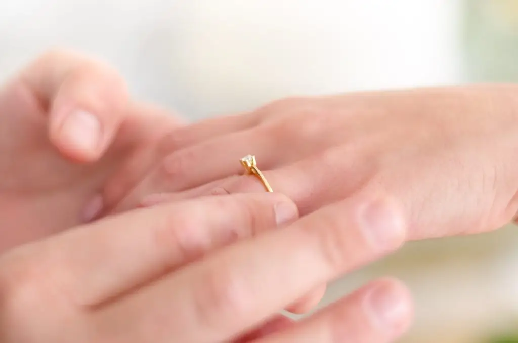 woman trying on a gold ring before resizing it