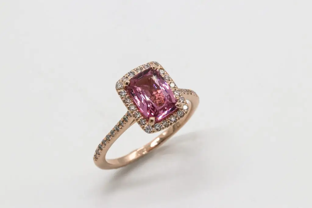 february birthstone amethyst gold ring surrounded by diamonds on a white background