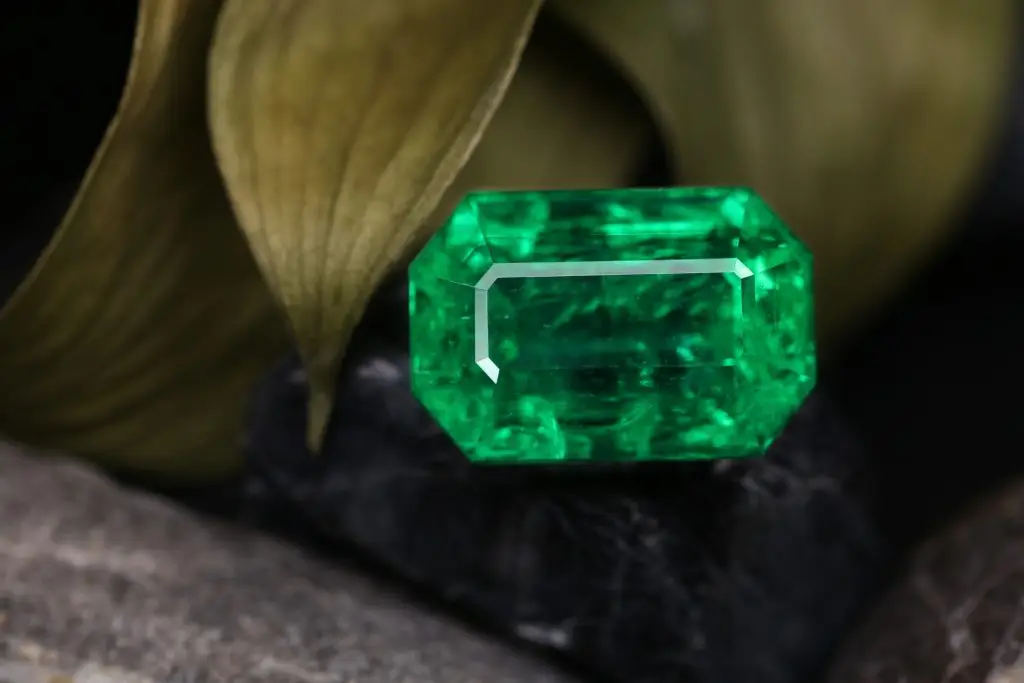 May's birthstone the emerald gemstone on a black backdrop