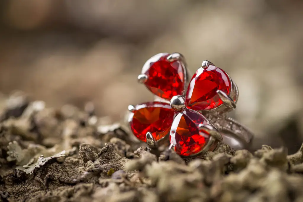 a right-hand ring that has a large red gemstones in the shape of a flower