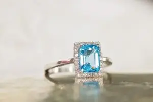 blue topaz ring with an emerald cut surrounded by diamonds