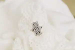 unique rectangle filigree diamond ring placed on a white lace handkerchief