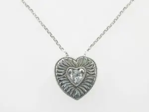 hand-engraved heart diamond necklace on white background 