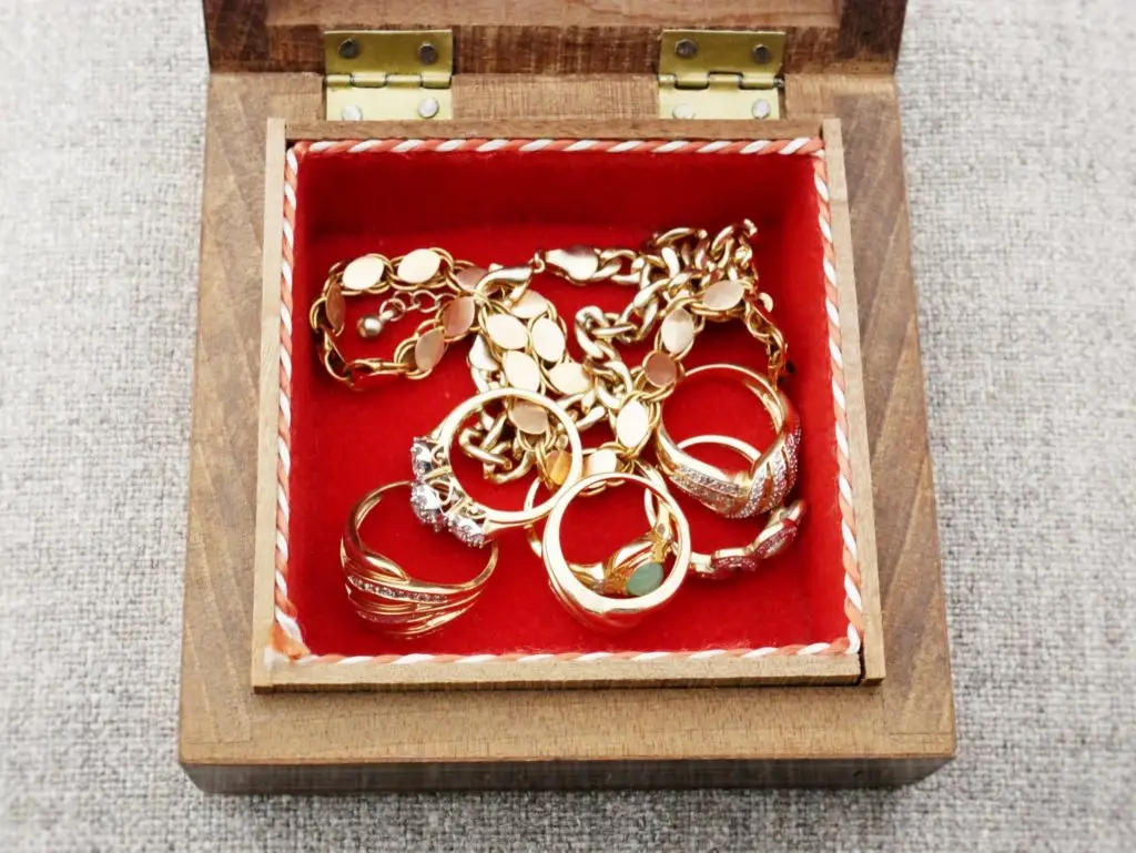 wooden jewelry box filled with old gold rings and other old gold jewelry