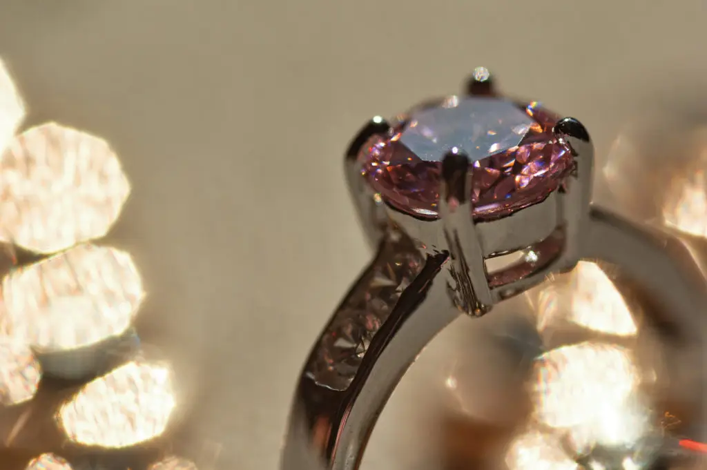 closeup shot of a ring with pink sapphire and small diamonds