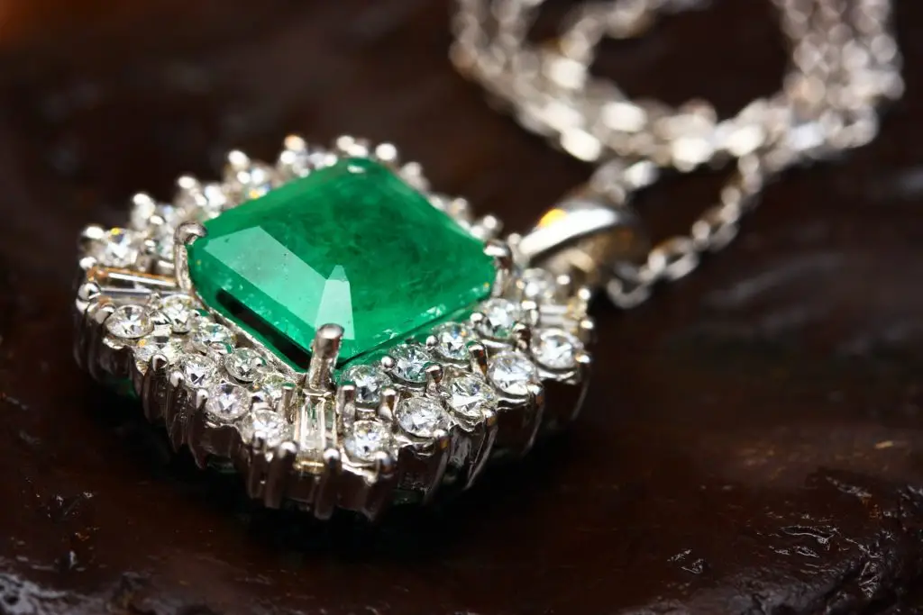 emerald jewelry laid over a maroon cloth