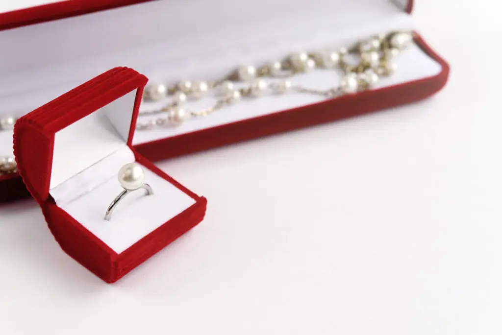 a pearl ring and a pearl necklace sitting in open boxes to decide the best ways to wear pearl jewelry