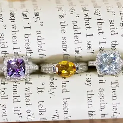 birthstone gemstone rings sets in a row in the spine of a book 