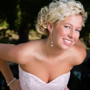 close up view of a blonde teen in her prom dress wearing pearl and diamond pendant earrings