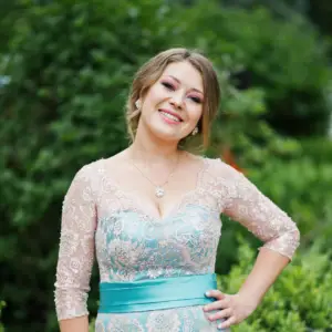 teen girl in her prom dress wearing a teal dress and a pendant necklace with diamond earrings