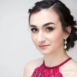 Close up of a young girl in a red prom dress with long diamond earrings for her prom jewelry