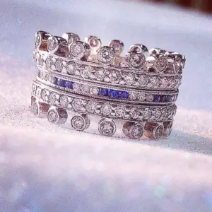 A stack of gemstone rings bands with diamonds and blue sapphires