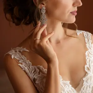 head and shoulders shot of a romantic style bride wearing a lace dress and large pendant diamond filigree earrings