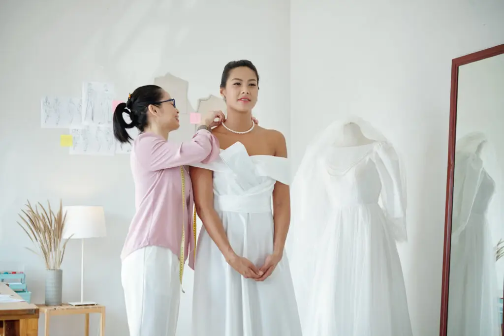 woman at bridal salon trying on her dress and choosing her bridal jewelry style