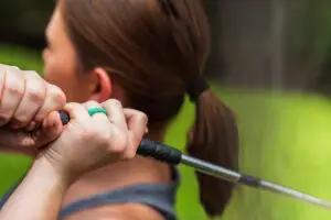 Woman holding a golf club over her shoulder wearing a teal Casual Carats diamond silicone ring