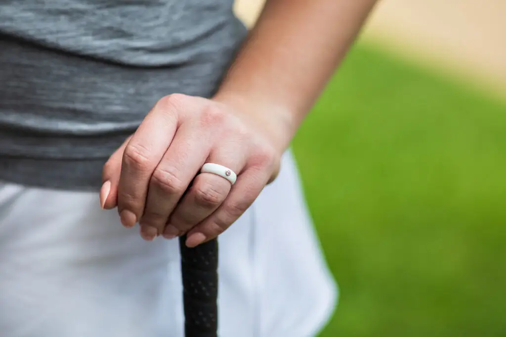 woman's hand over the grip of a golf club wearing a white Casual Carats diamond silicone ring