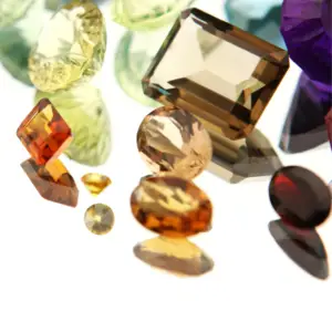 Several topaz gemstones in fall gemstone colors on a white background