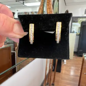 Double bar channel earrings with a black background featuring yellow gold and diamonds