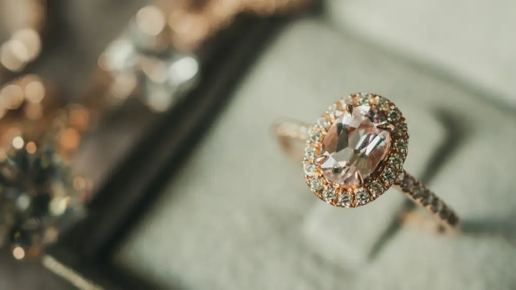 A diamond ring in a box with christmas lights in the background