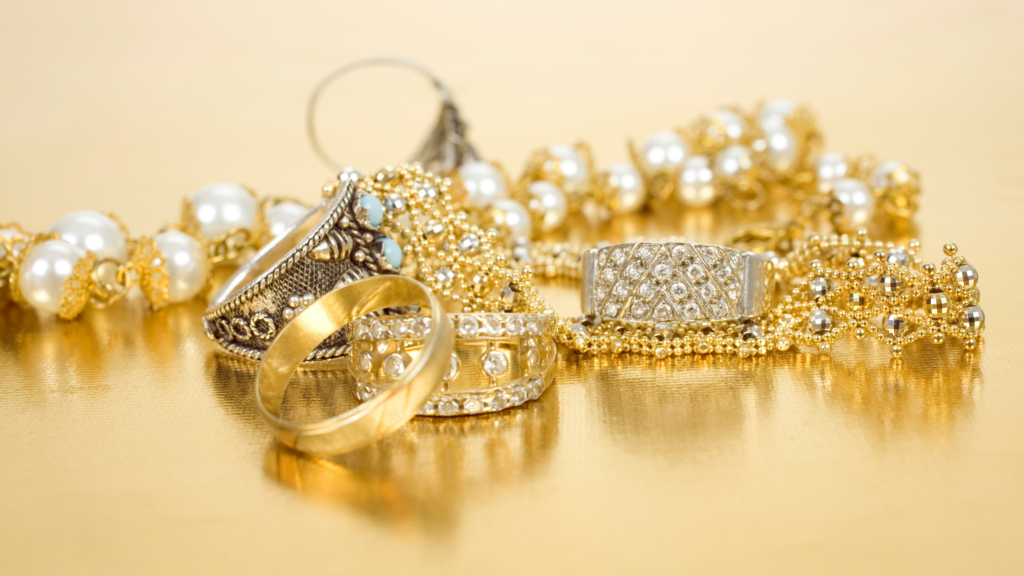 Pearl, gold and diamond jewelry on a gold background