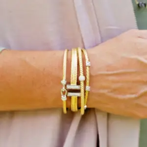 gold bangle bracelets hang on a woman's wrist