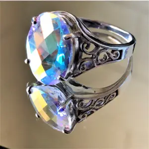 A white topaz gemstone ring sitting on a mirror