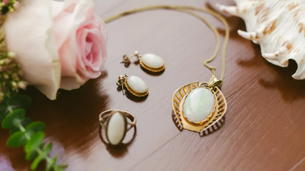 Opal gemstone jewelry on a table surrounded by roses