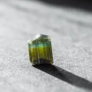 a tourmaline gemstone on a gray background 