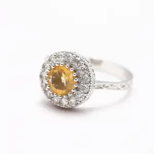  a yellow sapphire ring with diamond on a white background