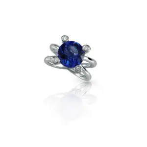 A round cut iolite gemstone ring with white gold setting on a white background