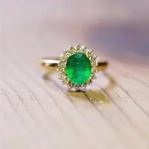 An emerald oval gemstone ring in yellow gold