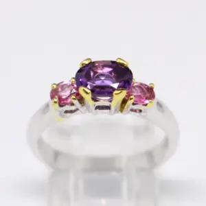 An amethyst oval gemstone ring with pink sapphire oval gemstones on each side 