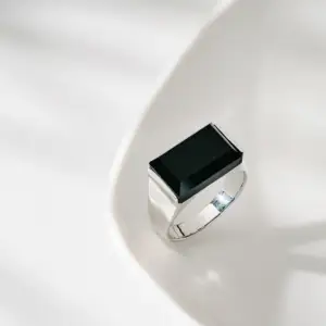 A silver ring with a black rectangular gemstone