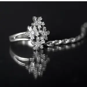 A white gold diamond ring with diamonds in the shape of small flowers