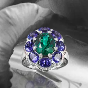 an emerald surrounded by blue sapphire ring