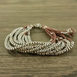 a leather corded bracelet with small gold beads