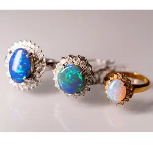 Three opal gemstone rings sitting in a row